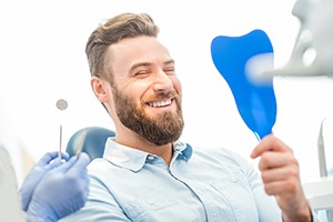 man smiling in dental mirror 