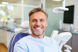 Middle-aged man smiling in dental treatment chair