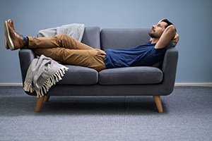 Relaxed man lying on sofa