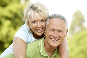 An older couple with dental implants in Fort Lauderdale smiling outside