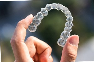 Dental patient holding up Invisalign tray in Fort Lauderdale