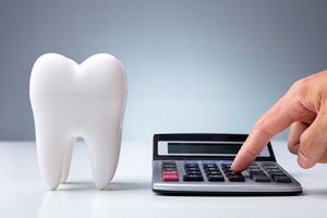 Model of a tooth next to a calculator