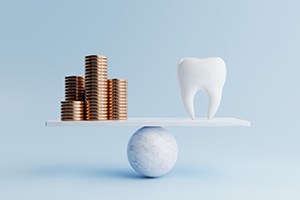 A balance beam weighing gold coins and a model tooth
