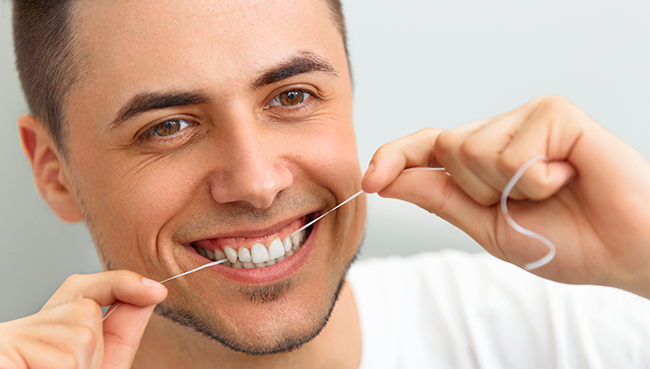 A man enjoying his favorite type of floss that is Fort Lauderdale, Florida dentist recommended to him.