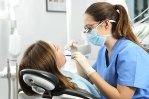 dentist cleaning patient's teeth